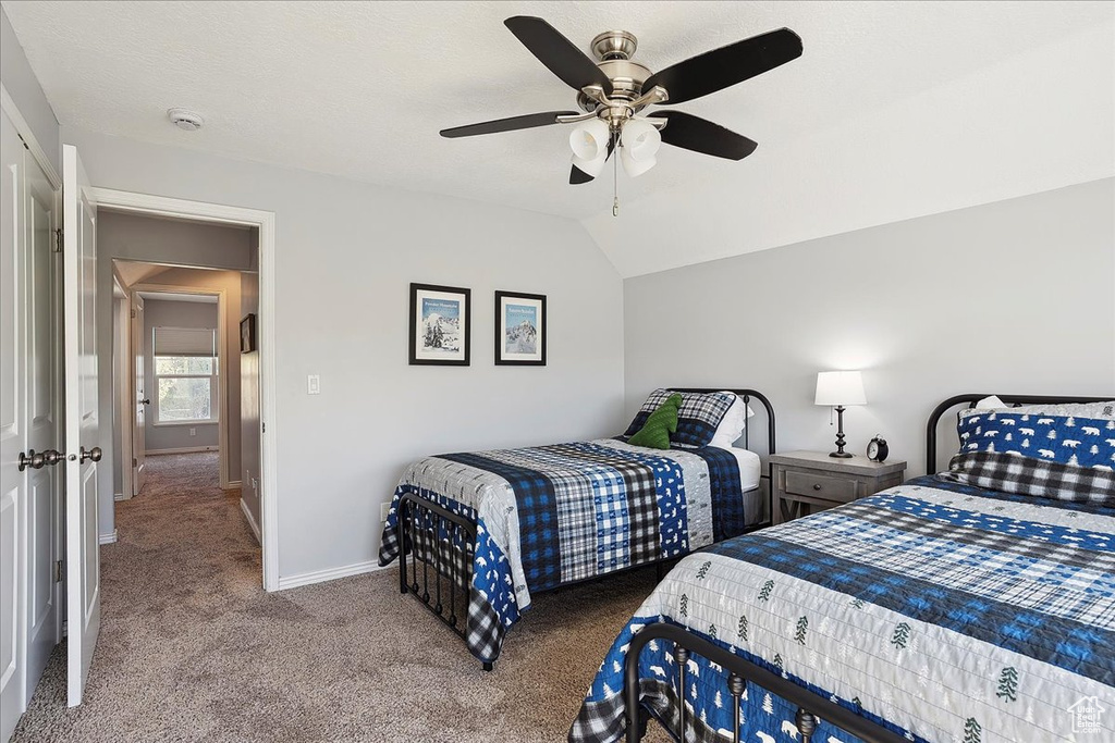 Bedroom featuring carpet floors, a ceiling fan, baseboards, and lofted ceiling