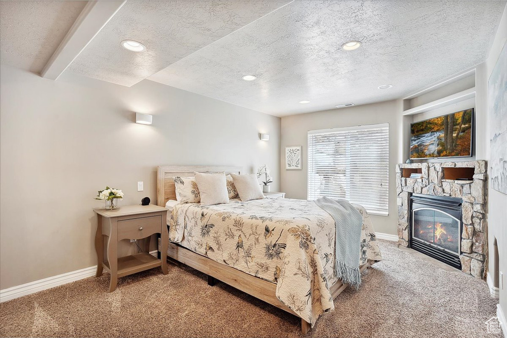 Bedroom with baseboards, a textured ceiling, and light carpet