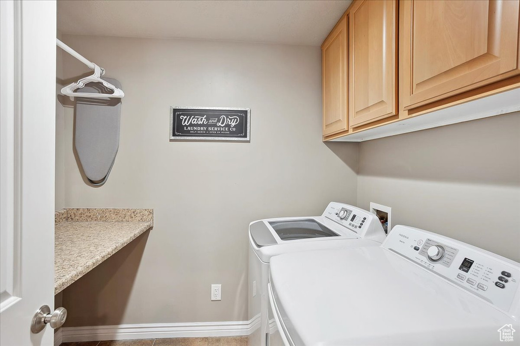 Laundry area featuring cabinet space, baseboards, and washing machine and dryer