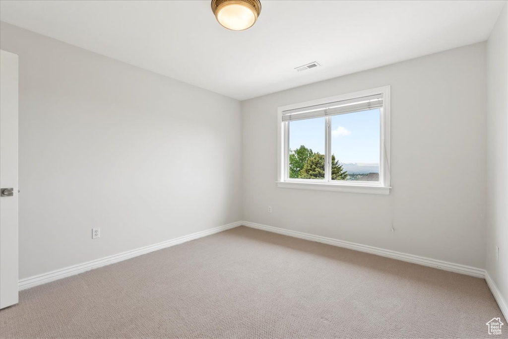 Unfurnished room with light colored carpet, baseboards, and visible vents