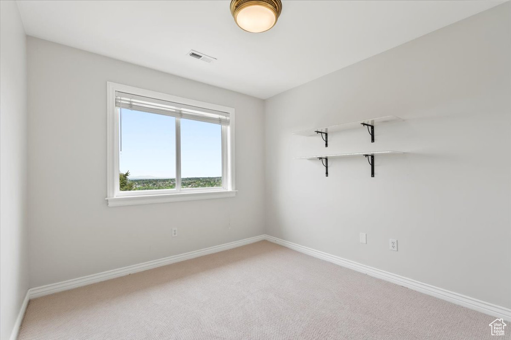 Spare room with light carpet, baseboards, and visible vents