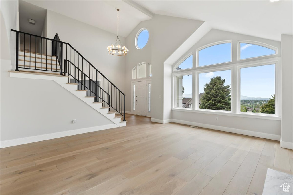 Foyer entrance featuring a wealth of natural light, stairway, and wood finished floors