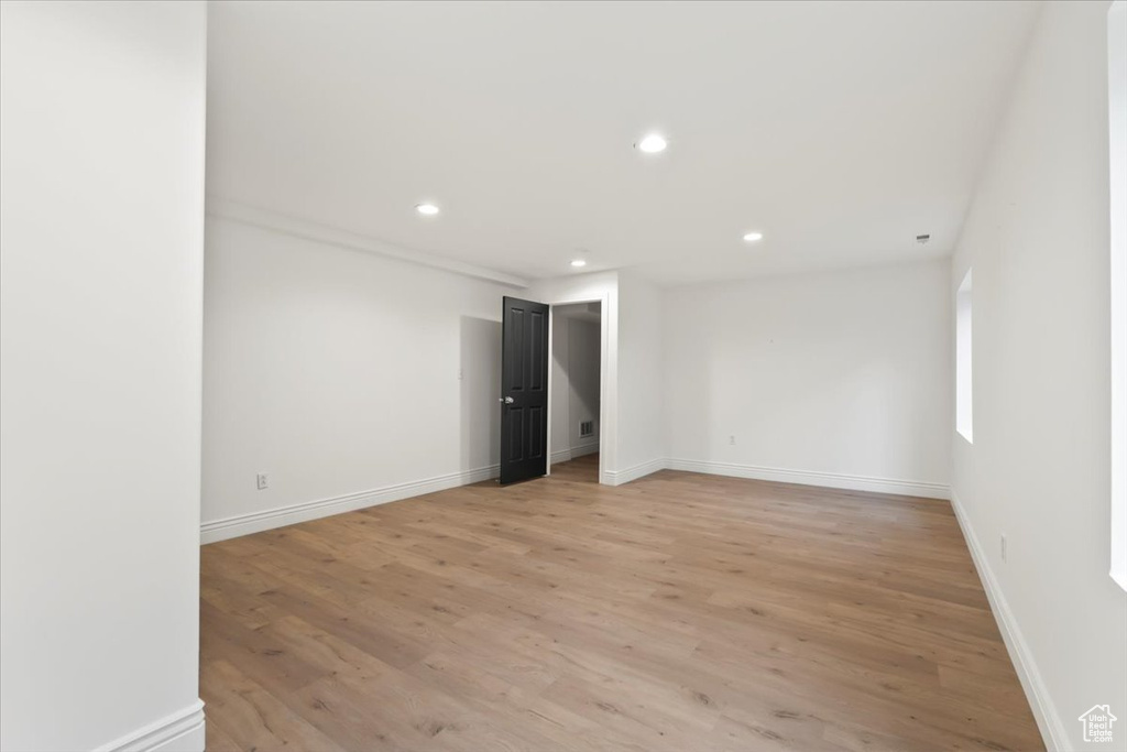 Empty room featuring baseboards, light wood finished floors, and recessed lighting