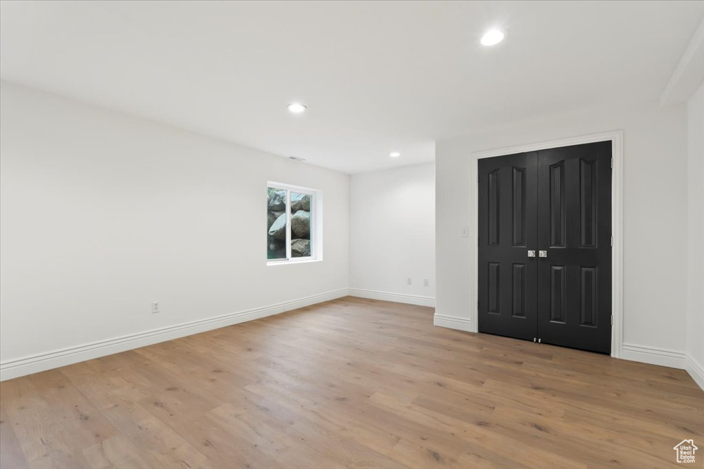 Unfurnished room with light wood finished floors, baseboards, and recessed lighting