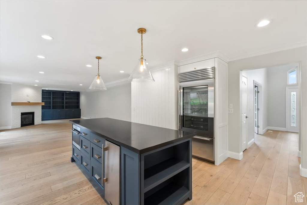 Kitchen with open shelves, dark countertops, light wood-type flooring, built in refrigerator, and recessed lighting