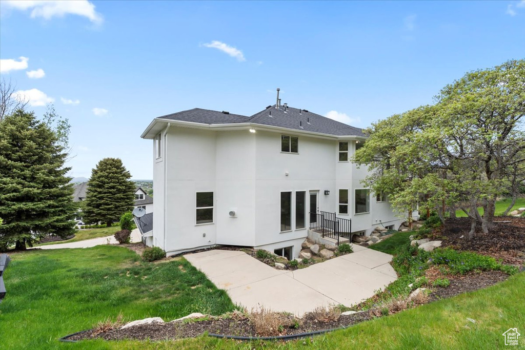 Back of property featuring stucco siding and a lawn