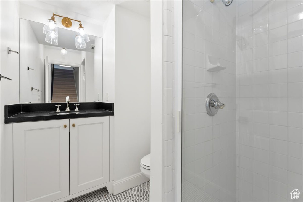 Full bath featuring vanity, toilet, a shower stall, and tile patterned flooring