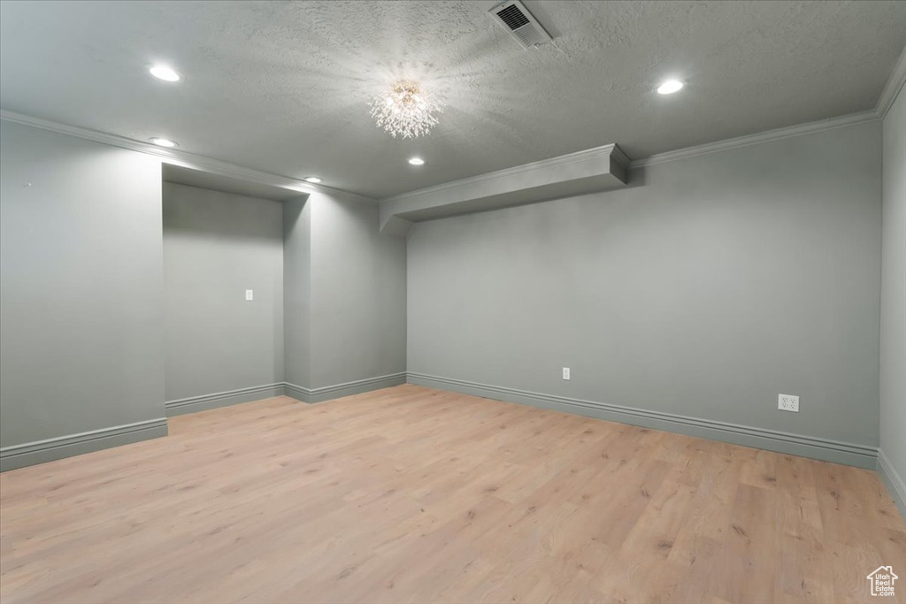 Basement with crown molding, baseboards, light wood finished floors, and recessed lighting