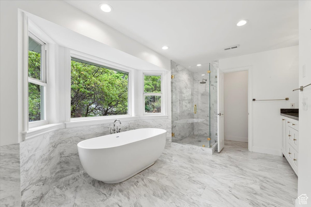 Bathroom with marble finish floor, vanity, a marble finish shower, visible vents, and a freestanding bath