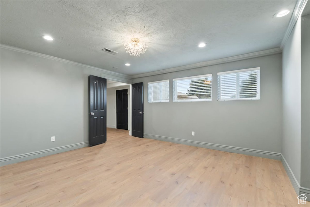 Empty room with visible vents, ornamental molding, and recessed lighting