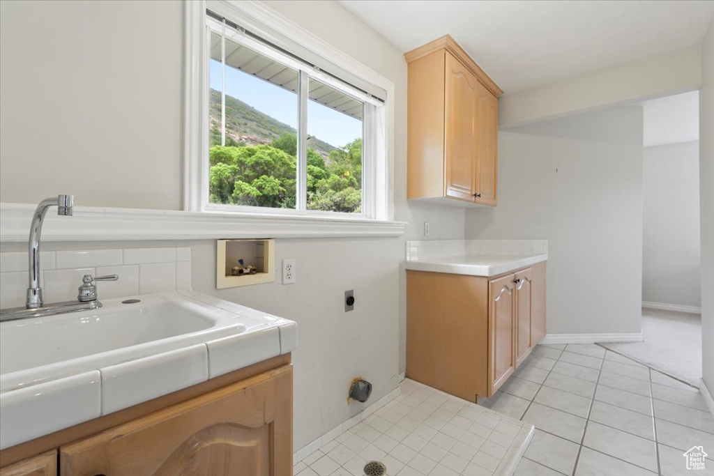 Laundry area featuring a wealth of natural light, hookup for a washing machine, cabinet space, and hookup for an electric dryer