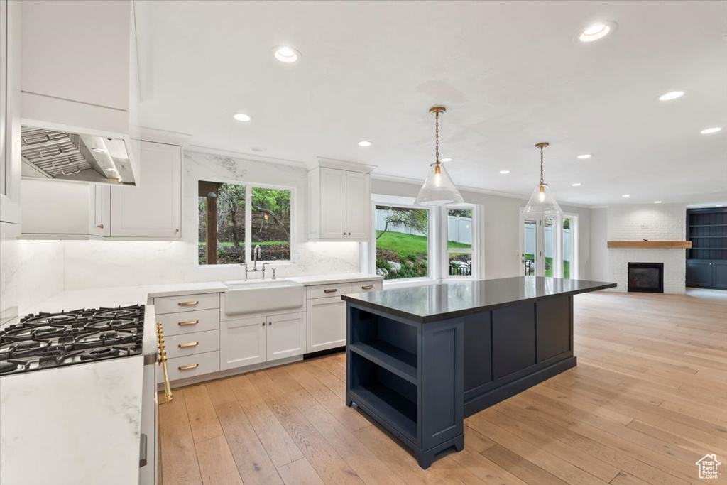 Kitchen with white cabinetry, backsplash, open shelves, and a sink