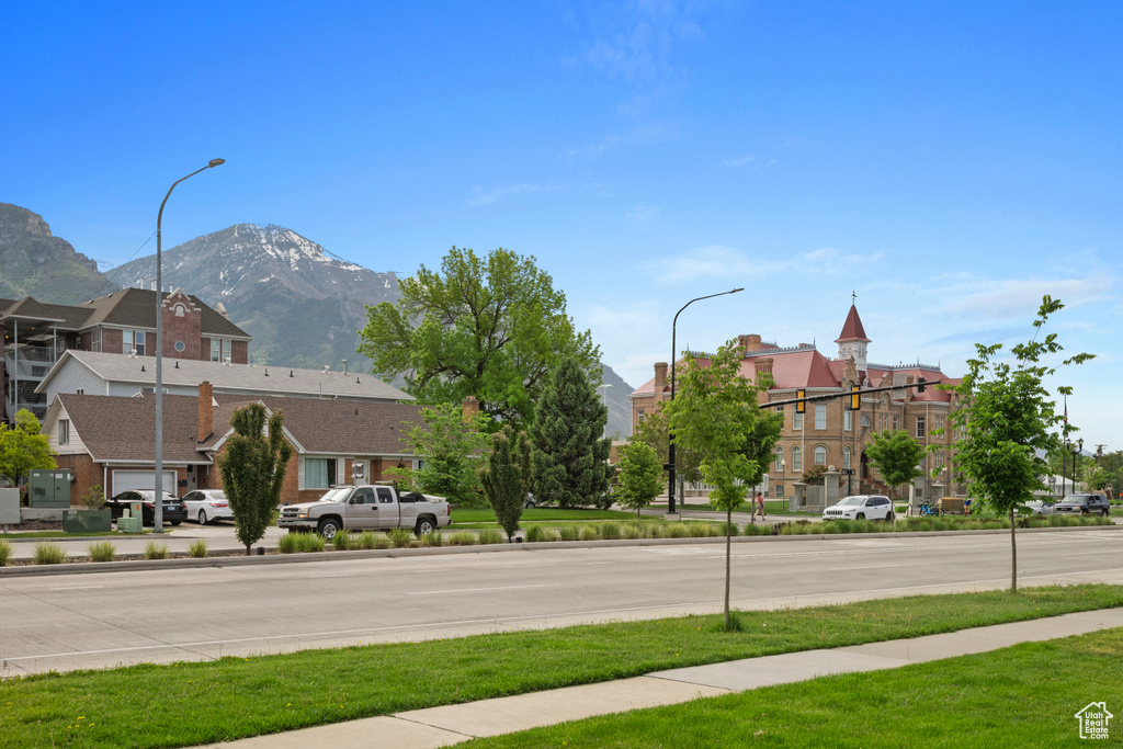 View of street with street lights, a mountain view, and sidewalks
