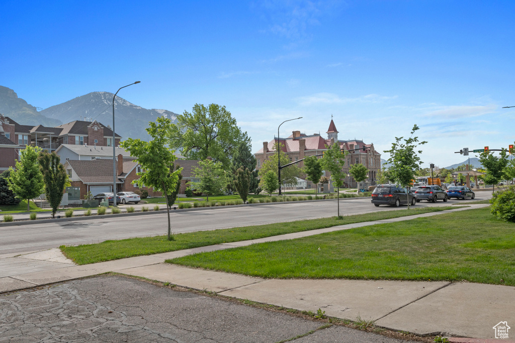 View of road featuring a residential view, sidewalks, a mountain view, and street lights