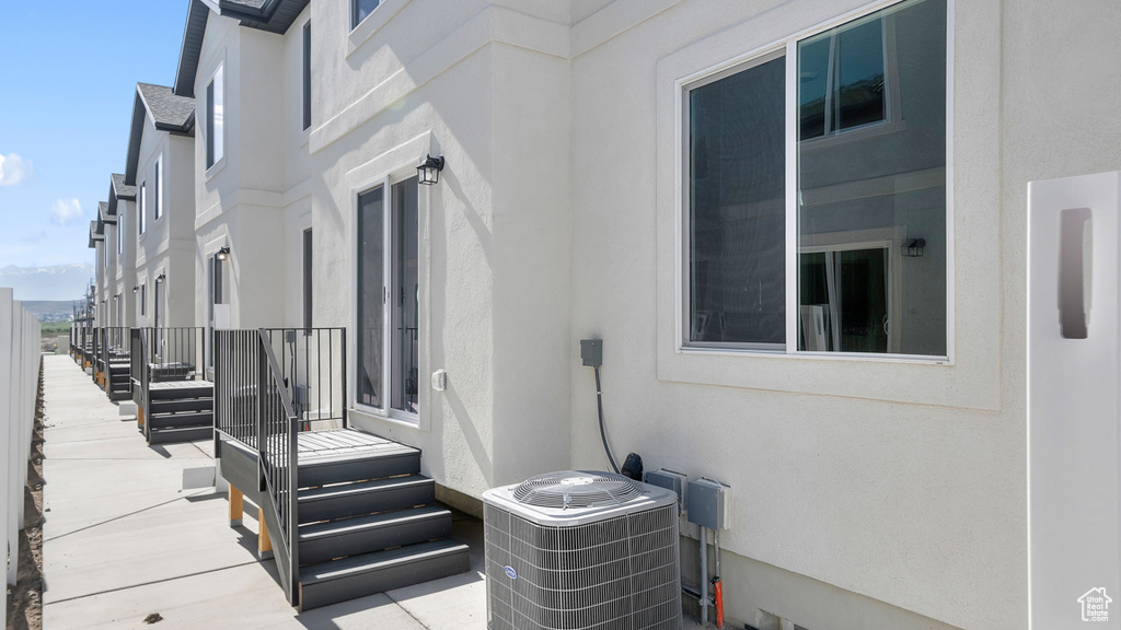 View of property exterior with central AC unit and stucco siding