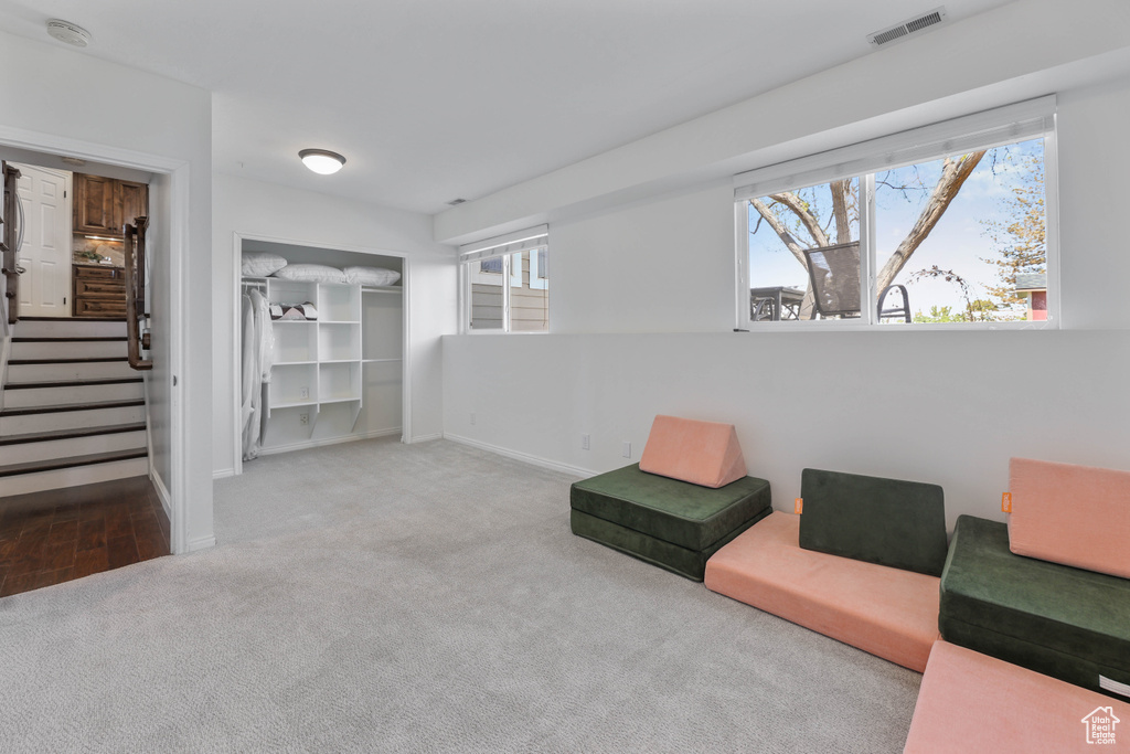 Living area with baseboards, carpet, stairs, and visible vents