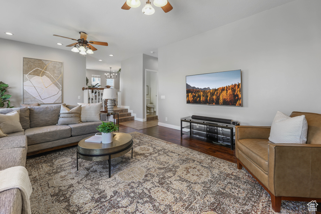 Living area with recessed lighting, baseboards, ceiling fan with notable chandelier, and wood finished floors