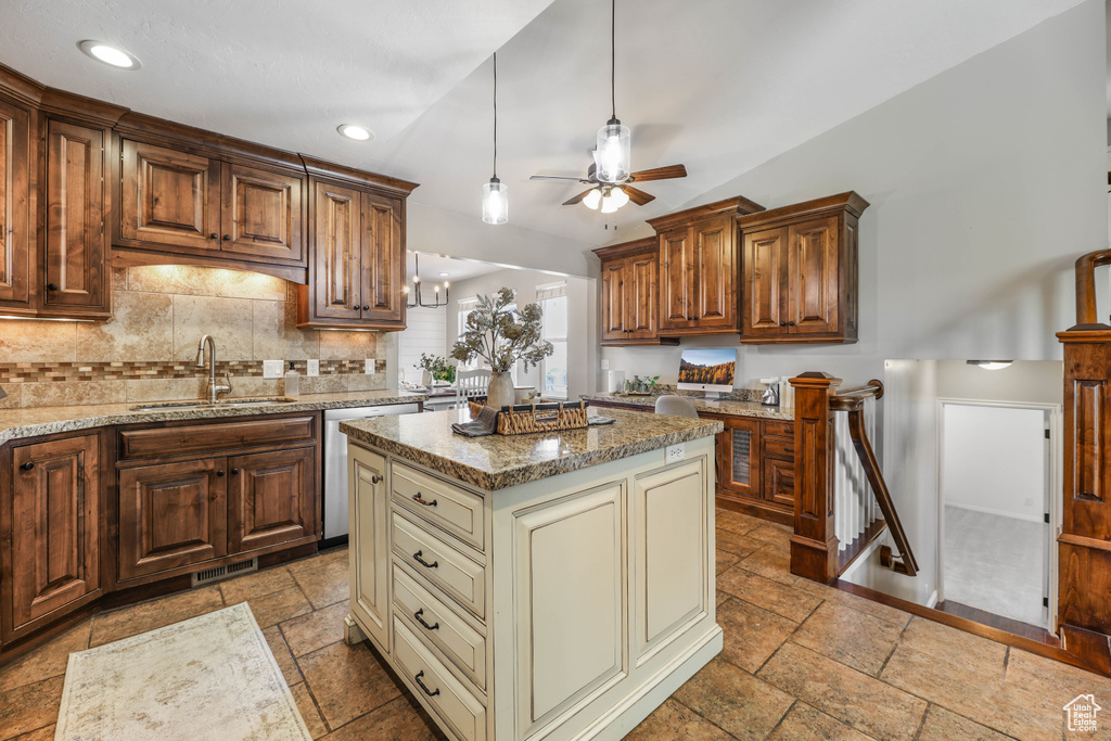 Kitchen featuring stone tile flooring, decorative backsplash, ceiling fan, cream cabinets, and a sink