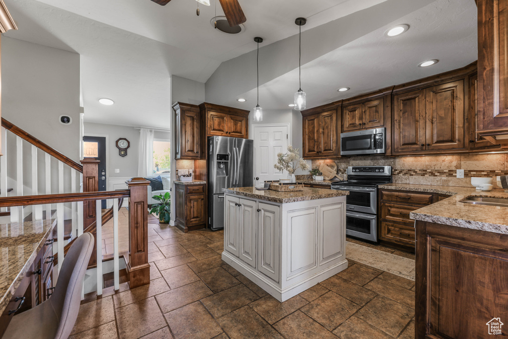 Kitchen featuring appliances with stainless steel finishes, light stone countertops, backsplash, and recessed lighting
