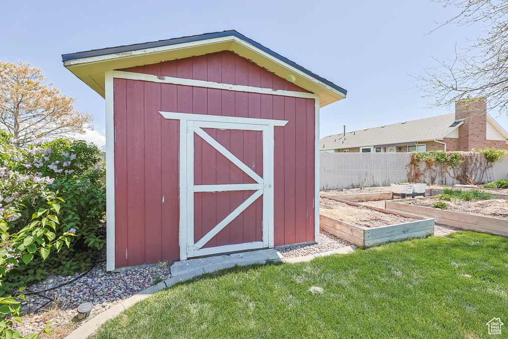 View of shed featuring a garden and fence