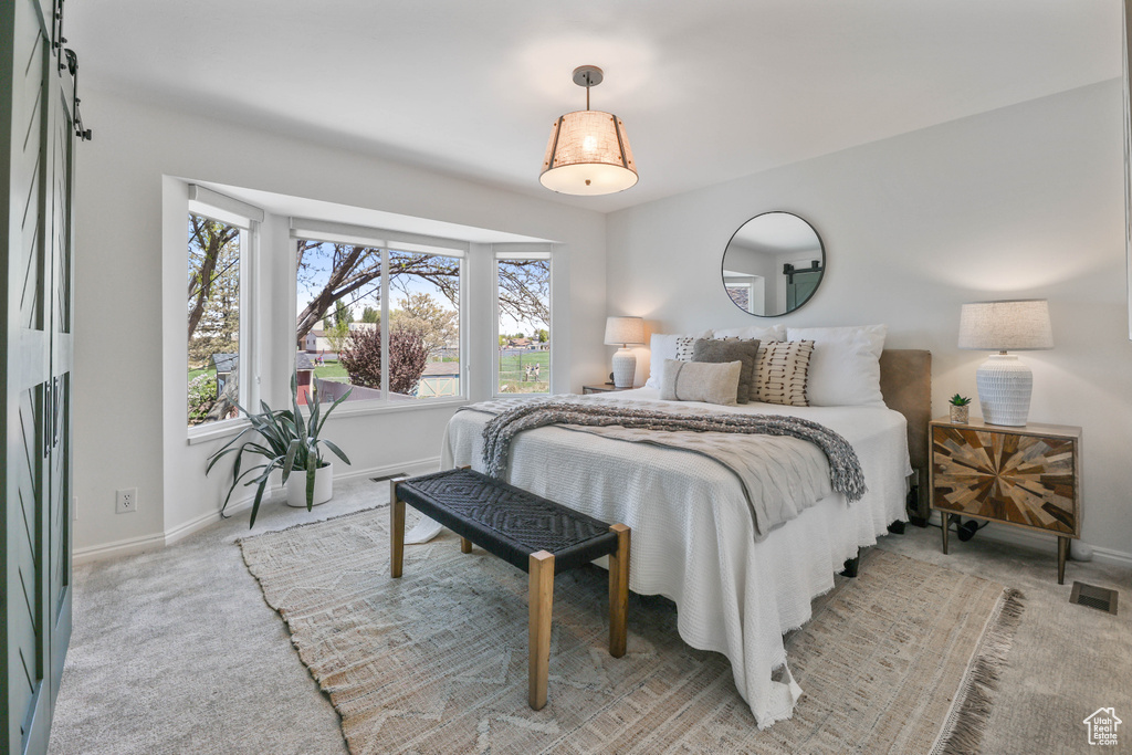 Bedroom featuring baseboards, visible vents, and light colored carpet