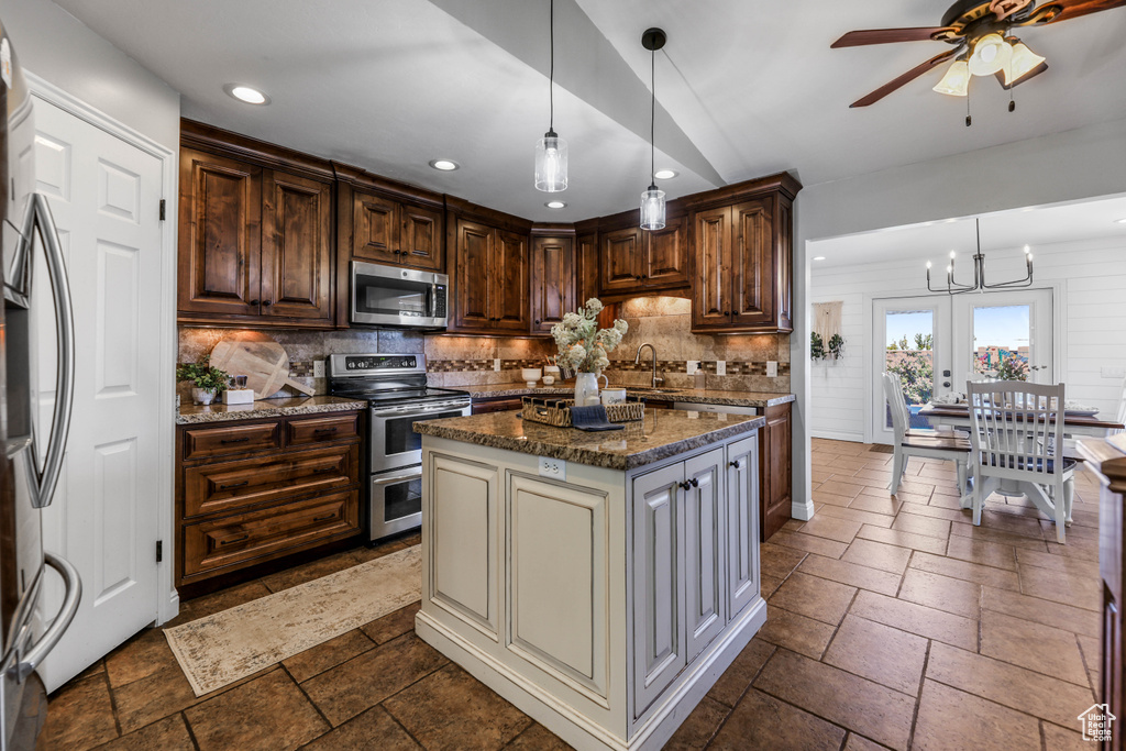 Kitchen with decorative backsplash, stainless steel appliances, recessed lighting, and stone tile flooring
