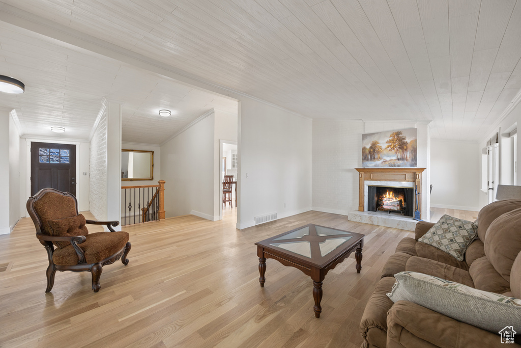 Living area featuring light wood-style floors, ornamental molding, plenty of natural light, and visible vents