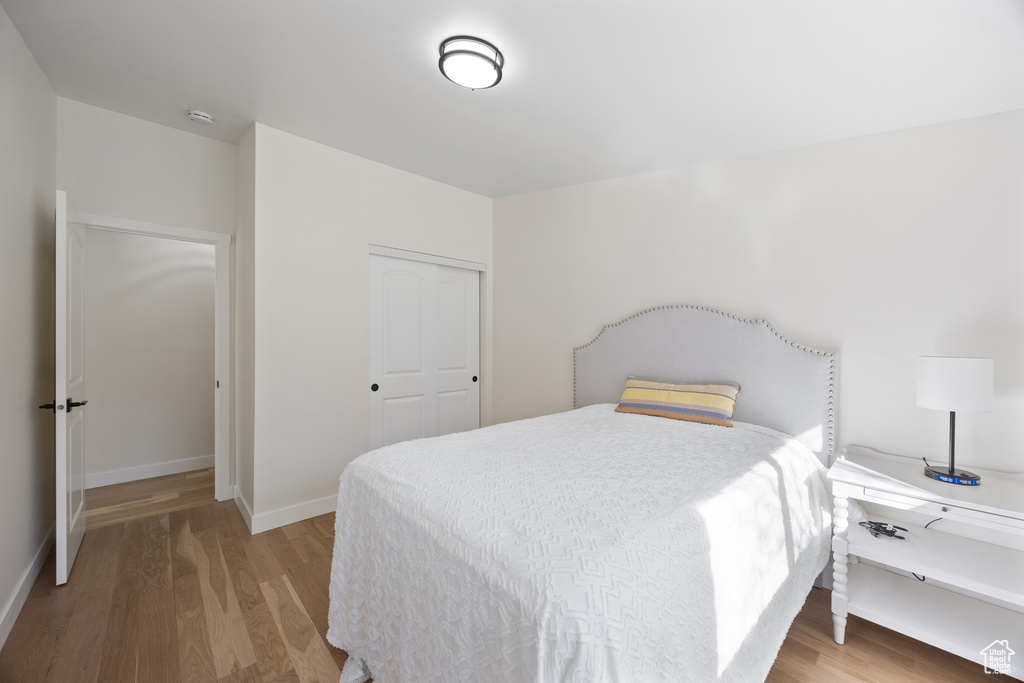 Bedroom featuring a closet, baseboards, and light wood-type flooring