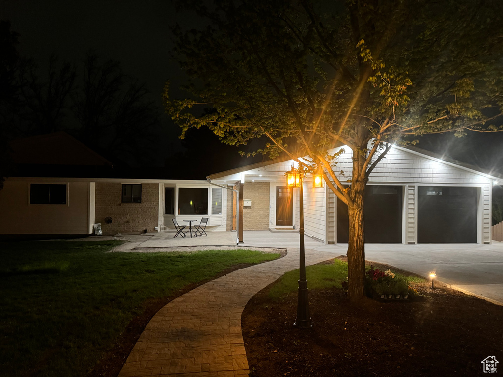 View of front of home with a lawn, concrete driveway, and brick siding