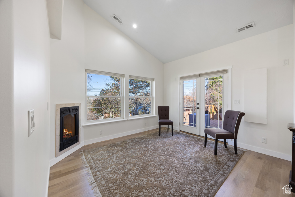 Sitting room featuring high vaulted ceiling, visible vents, french doors, and light wood-style floors