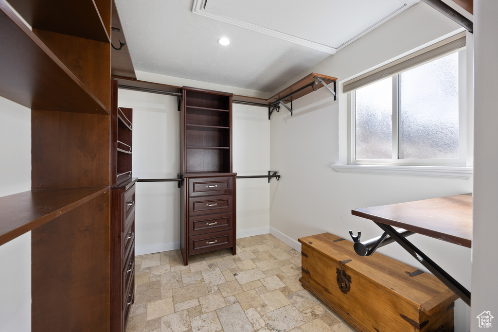Spacious closet featuring stone finish flooring