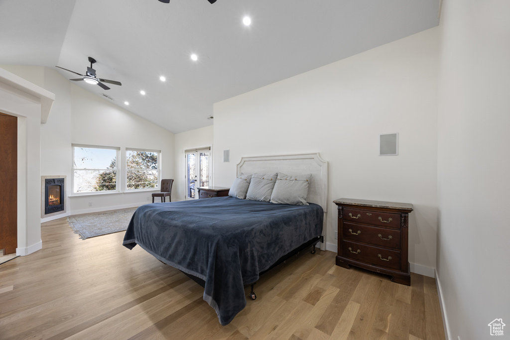 Bedroom with light wood-style floors, recessed lighting, baseboards, and high vaulted ceiling