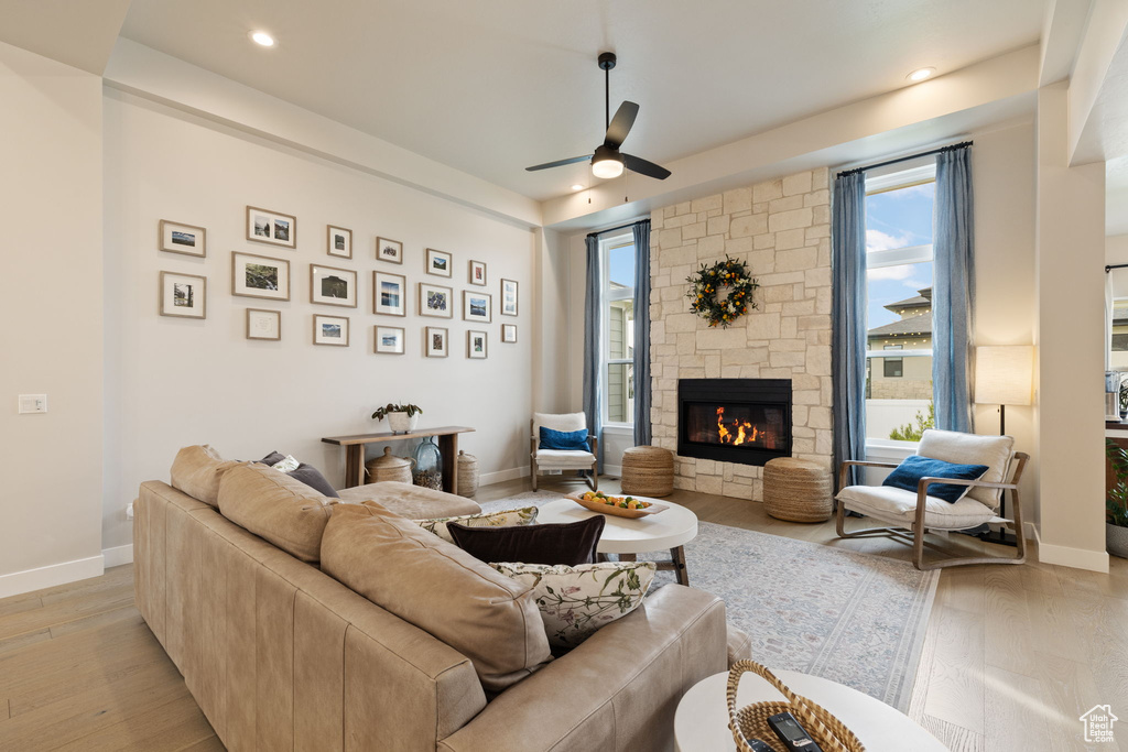 Living room featuring recessed lighting, light wood-style flooring, ceiling fan, and a fireplace