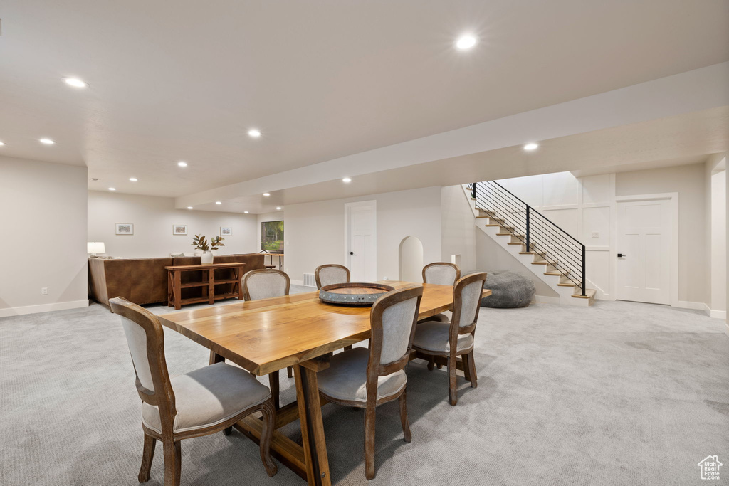 Dining room featuring light colored carpet, recessed lighting, stairway, and baseboards