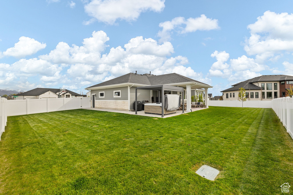 Back of house featuring a shingled roof, a patio area, an outdoor living space, a yard, and a fenced backyard