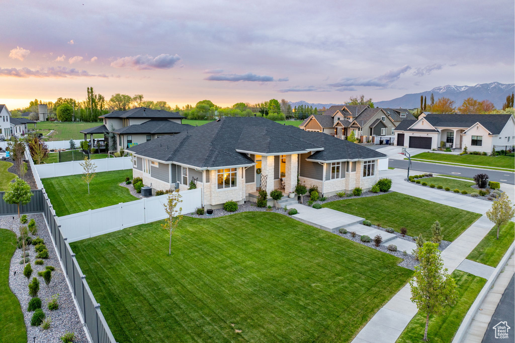 Ranch-style house featuring roof with shingles, a front lawn, a residential view, and a fenced backyard