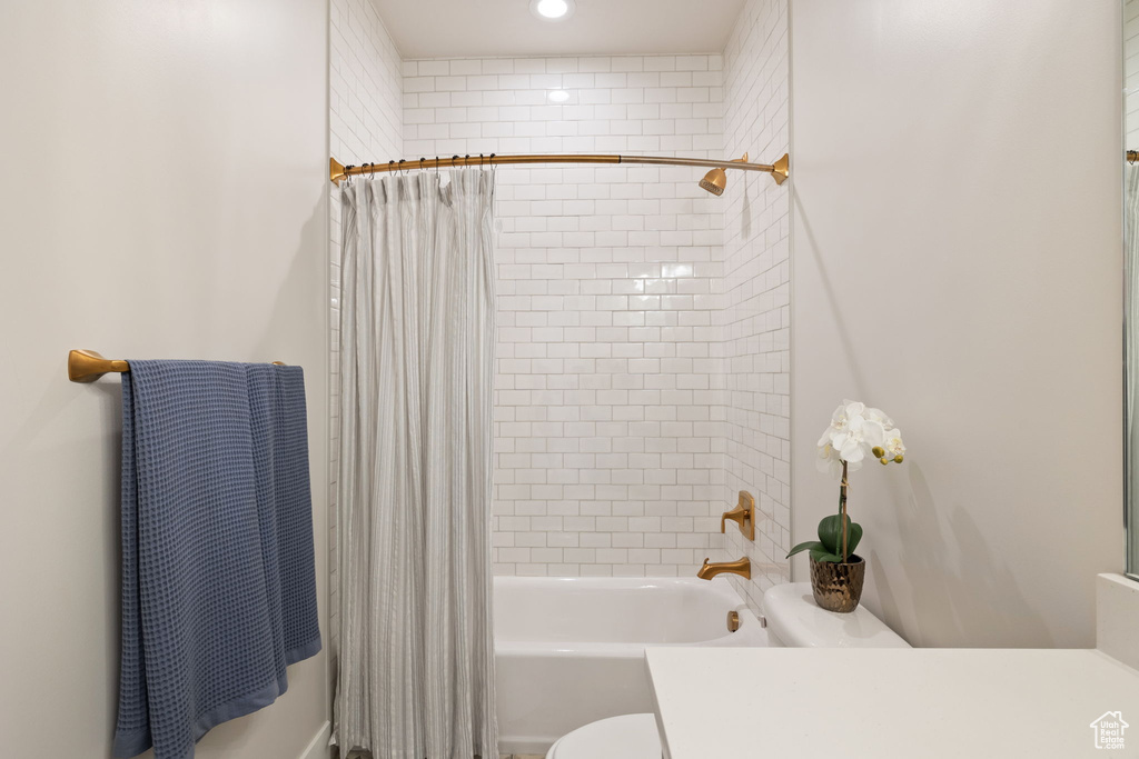 Full bath with recessed lighting, shower / bath combo with shower curtain, toilet, and vanity
