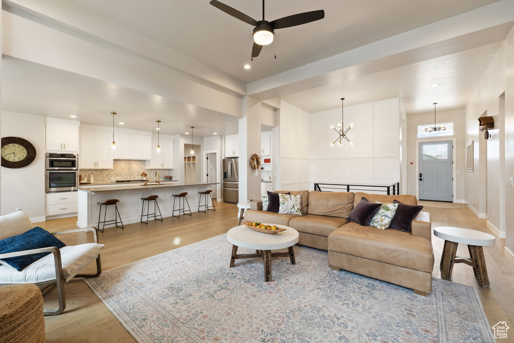 Living room featuring baseboards, recessed lighting, and light wood finished floors