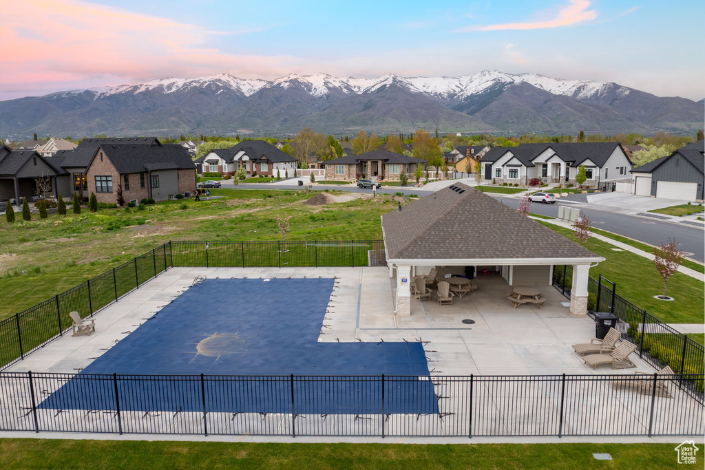 Community pool with fence, a patio area, and a residential view
