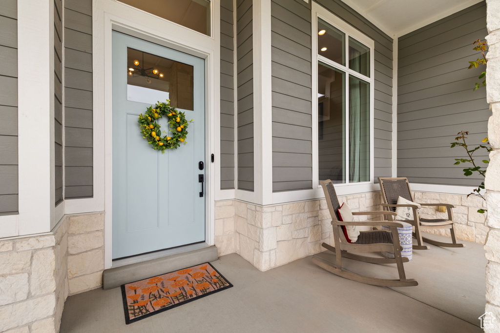 View of exterior entry featuring a porch and stone siding