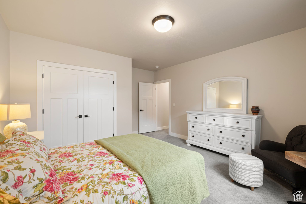 Carpeted bedroom featuring baseboards and a closet