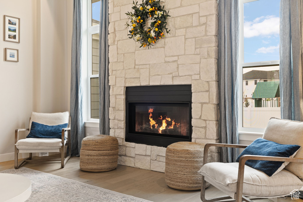 Sitting room with a fireplace, wood finished floors, and baseboards
