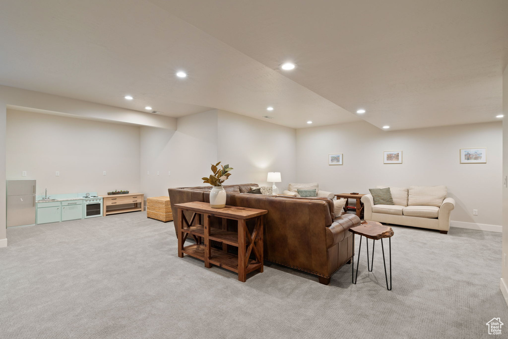 Living area featuring baseboards, recessed lighting, and light colored carpet