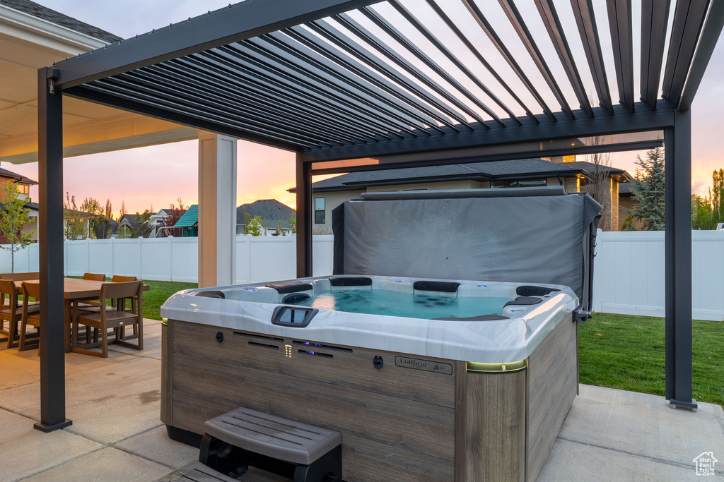View of patio / terrace with a pergola, outdoor dining area, a fenced backyard, and a hot tub