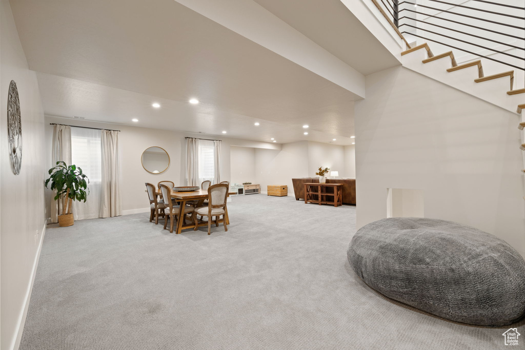 Carpeted dining space featuring baseboards, recessed lighting, and stairs