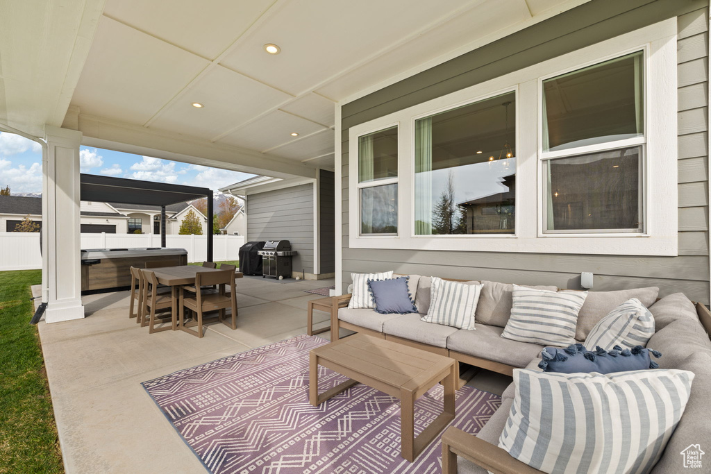 View of patio / terrace featuring an outdoor hangout area, fence, and a hot tub