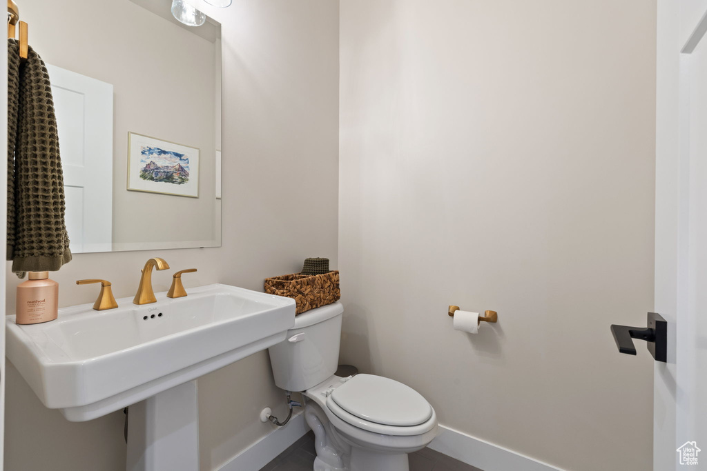 Half bathroom featuring toilet and baseboards