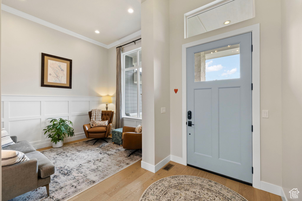 Entryway with visible vents, baseboards, recessed lighting, ornamental molding, and wood finished floors