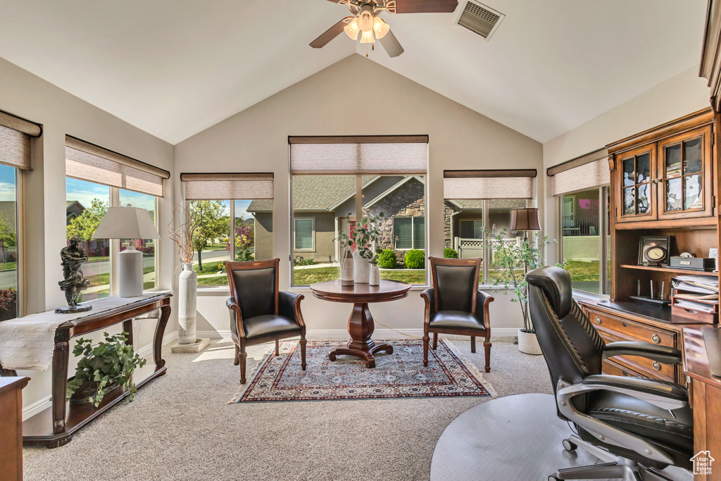 Carpeted office with a ceiling fan, baseboards, visible vents, and vaulted ceiling