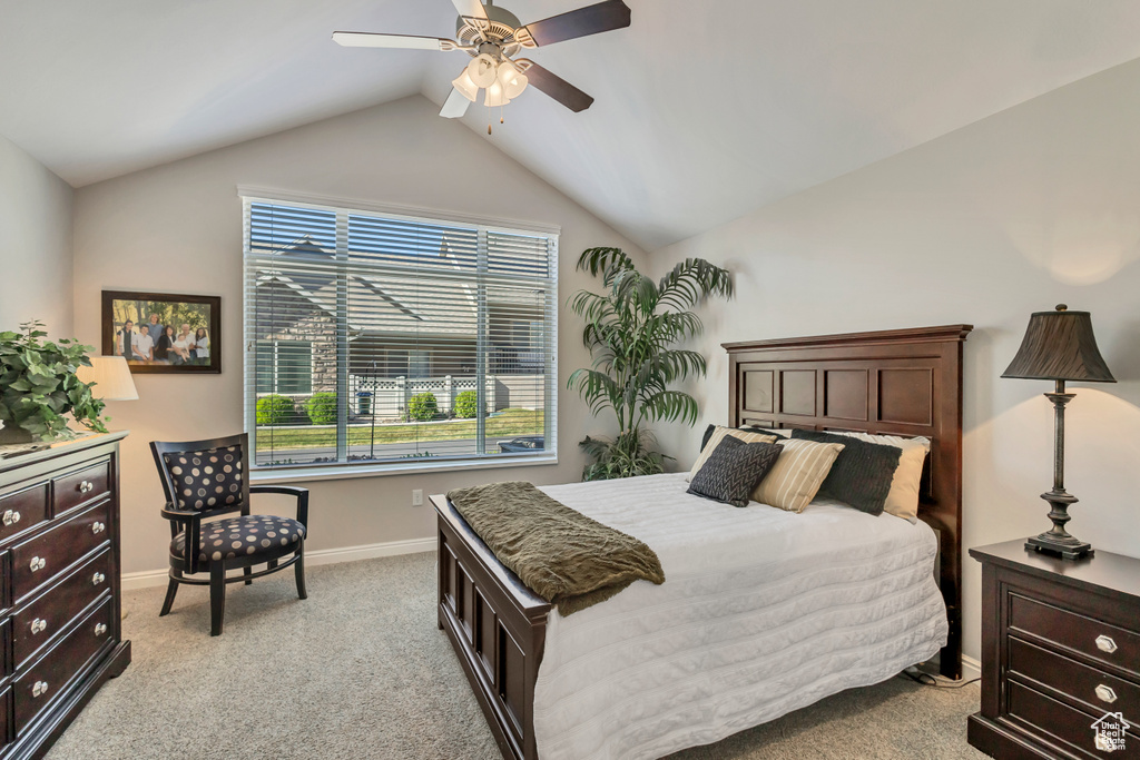 Bedroom featuring baseboards, ceiling fan, vaulted ceiling, and light colored carpet